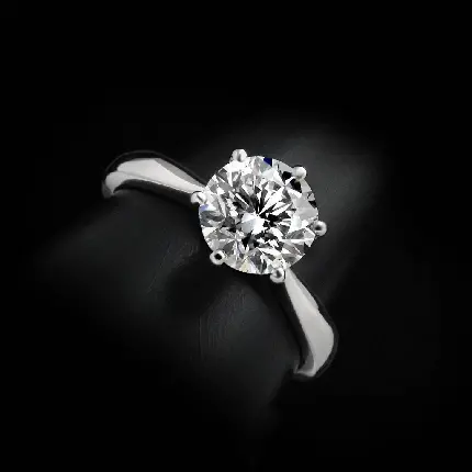 تصویر انگشتر الماس نقرە‌ای با نگین درشت در زمینە مشکی