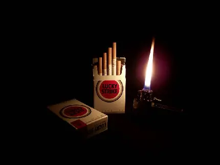 عکس زمینە خاموش از 2 بستە سیگار مارلبرو یکی باز شدە و دیگری بستە در کنار فندک روشن