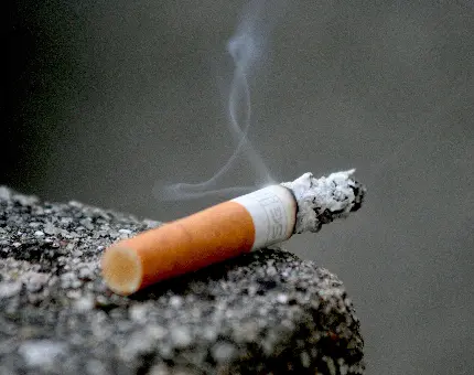 پس زمینە سیگار نصفە دود شدە بر روی سنگی باکیفیت عالی