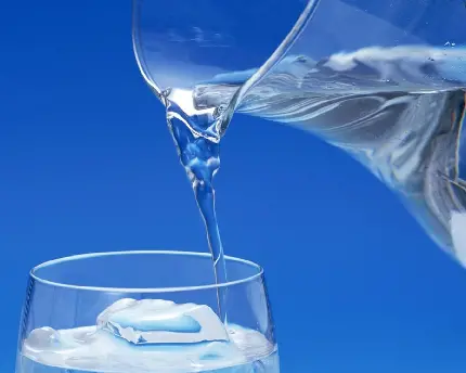 بک گراند آبی رنگ از لحظه ی ریختن آب آشامیدنی از پارچ به درون لیوان
