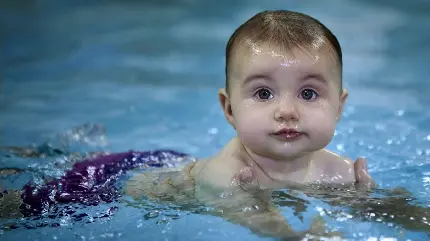 نمای دلنشین از شنا کردن نوزاد خوشگل دختر در استخر 2022