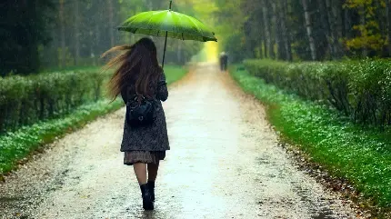 والپیپر بهاری خاص لپ‌تاب از دختری مو پریشان با چتری سبز رنگ در باران واقعی شدید