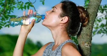 عکس باکیفیت عالی دختر ورزشکار در حال نوشیدن آب آشامیدنی مناسب گوشی