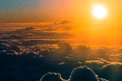 تصویر زمینه خورشید در حال غروب بر فراز ابرهای پرتراکم با کیفیت HD