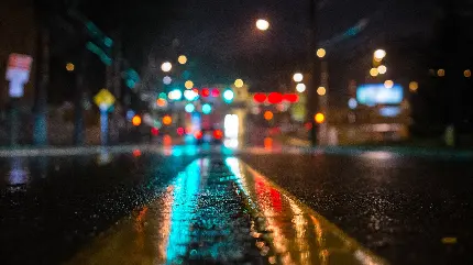 دانلود تصویر زمینە مات و ناپدیدار از خیابانی بارانی در شهری با چراغ‌های روشن