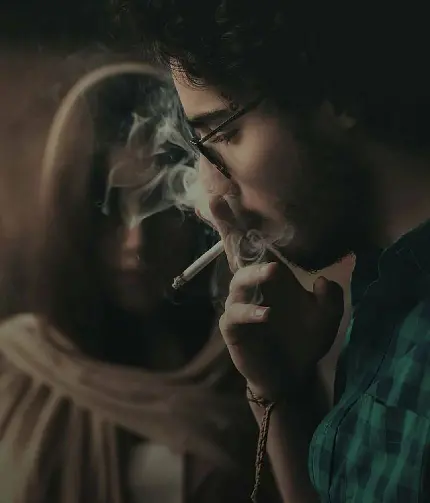 تصویر رمزآلود و تاریک از پسر سیگاری عاشق و یک دختر در نمای جالب