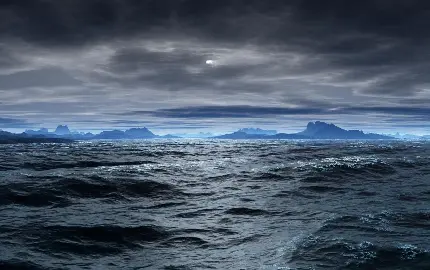 دانلود عکس مشوش از اقیانوس طوفانی و کوه آبی رنگ و آسمانی با ابر مشکی رنگ باکیفیت hd