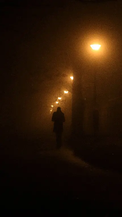 عکس تنهایی پسر غمگین زیر چراغ های خیابان در شب مه آلود