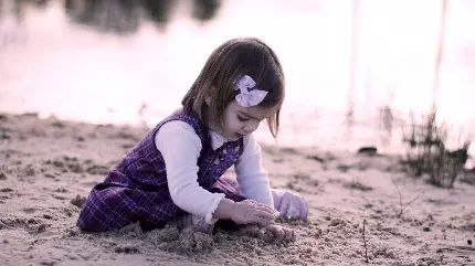 عکس دختر بچه زیبا در حال بازی کردن در ساحل
