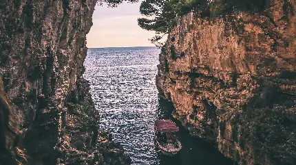 پست هنری قایق کوچک میان دو صخره در دریا برای instagram
