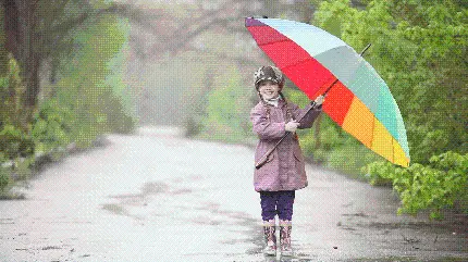 عکس قشنگ دختر بچه شاد و چتر رنگین کمان زیر باران