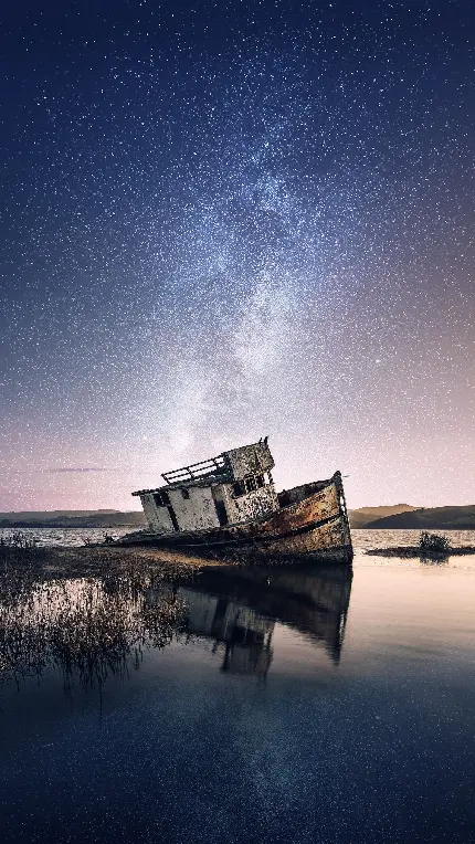 والپیپر قایق چوبی تنها و شکسته در شب ستاره باران مناسب آیفون