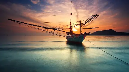 تصویر زمینه چشم نواز قایق صیادی در غروب زیبای دریا