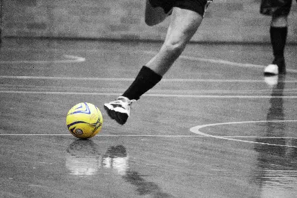 عکس سیاه سفید ورزش فوتسال و بازیکن حرفه ای حین ضربه به توپ