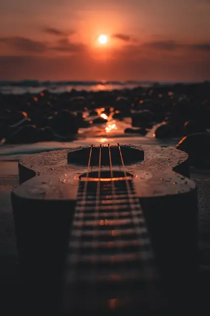 عکس هنری گیتار در غروب دریا برای زمینه آیفون 15