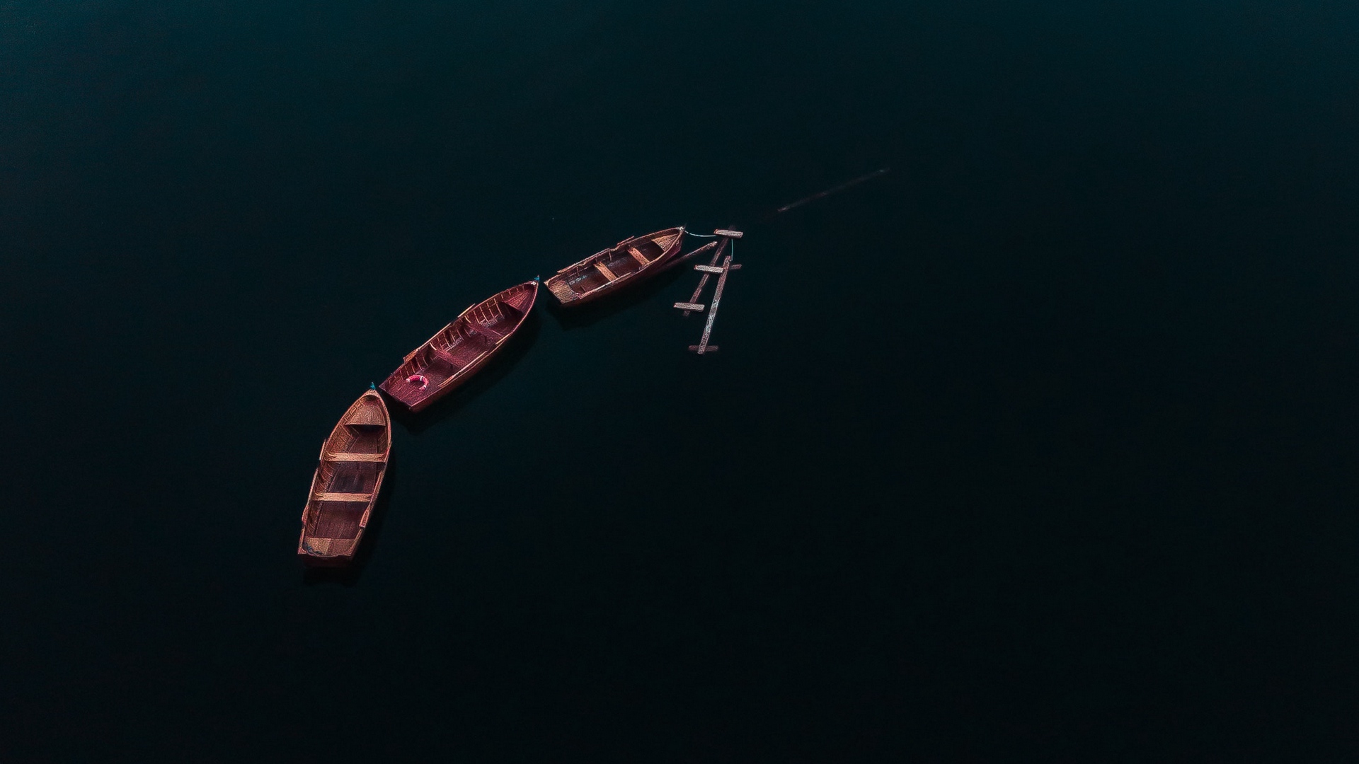 والپیپررویایی قایق های چوبی وسط دریا در کیفیت 4K برای دسکتاپ