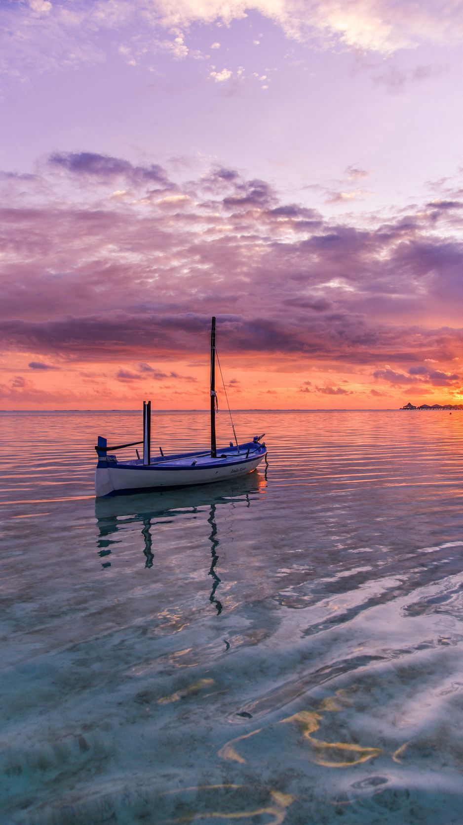 عکس زمینه شاهکار قایق چوبی در دریا زیر آسمان خوش رنگ غروب