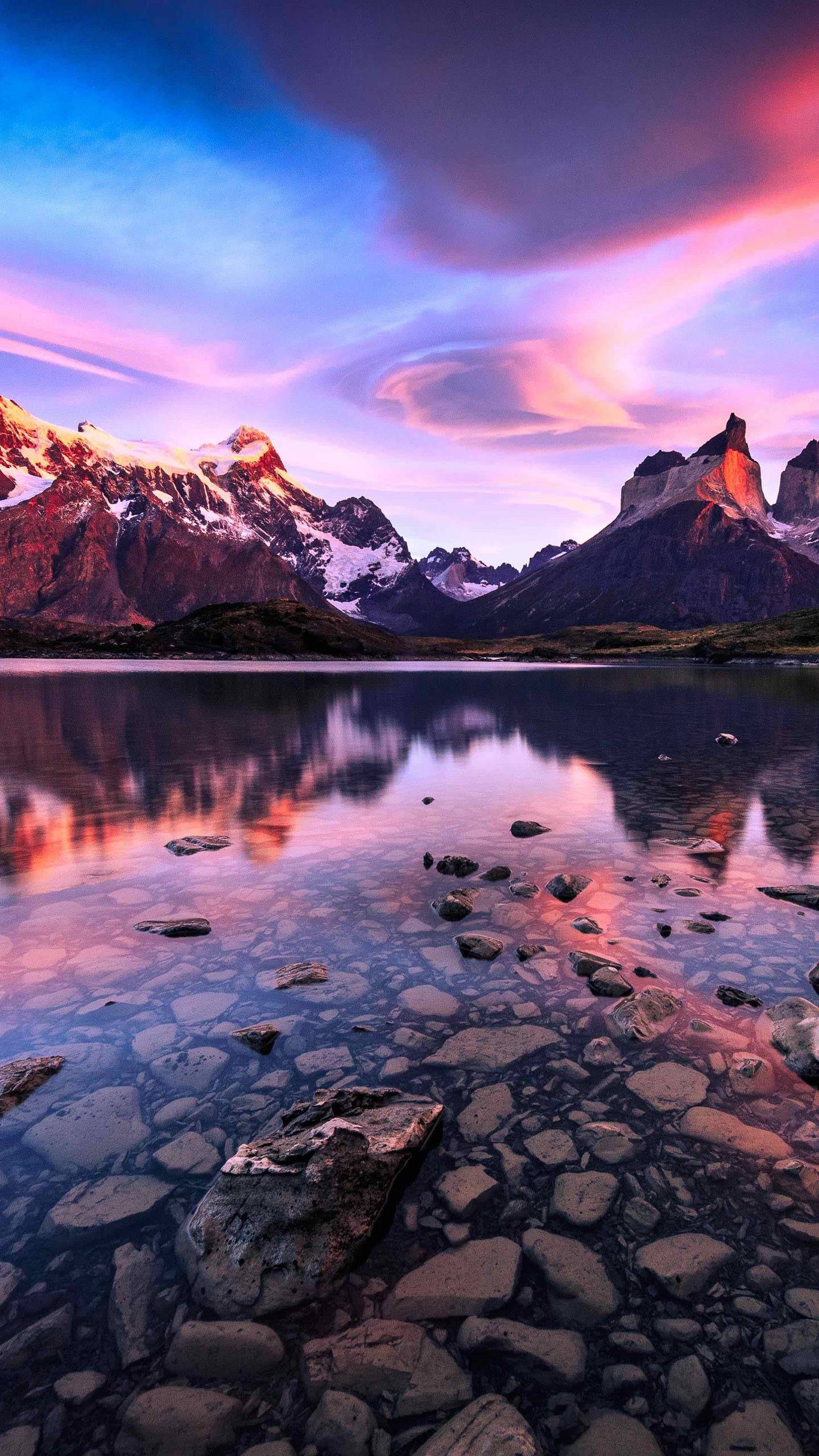 تصویر زمینه دریاچه صورتی با آب زلال روشن و کوه های برفی