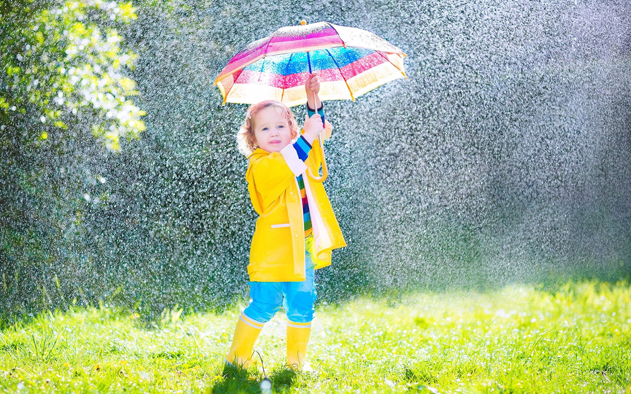 تصویر دختر بچه کیوت با چتر رنگی زیر باران فصل بهار