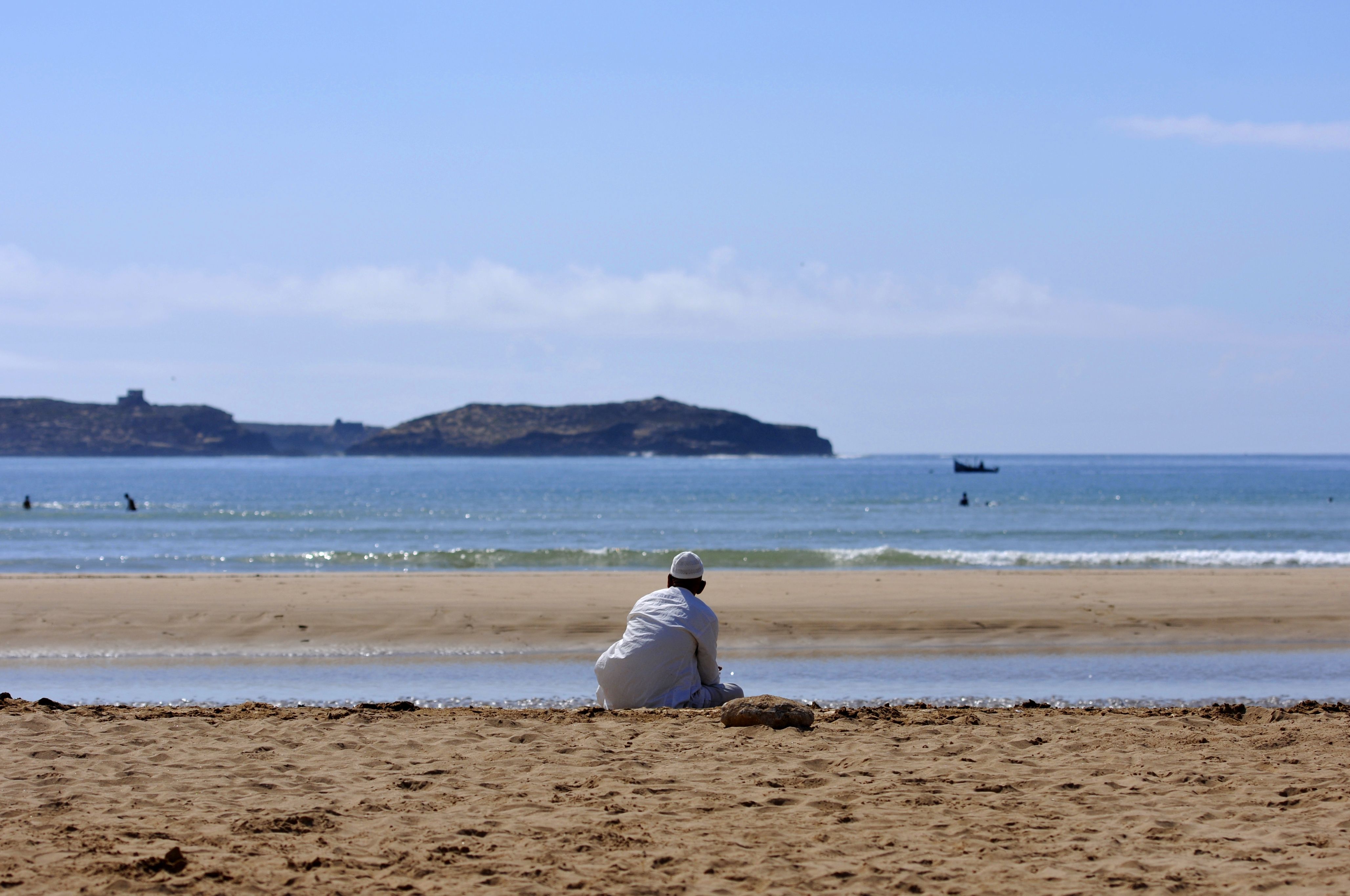 تصویر مرد مراکشی نشسته در ساحل در حال تماشای دریا
