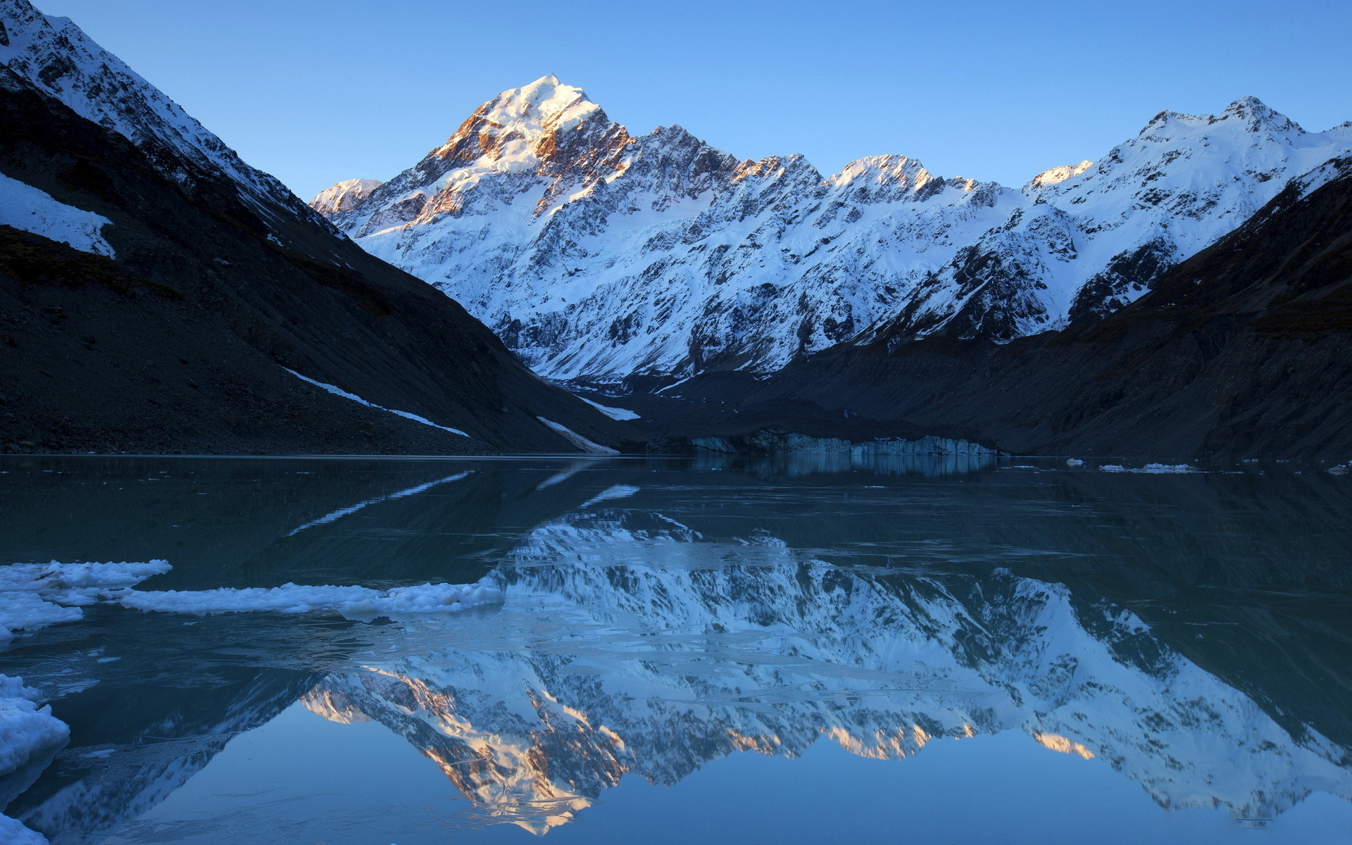 بک‌گراند انعکاس تصویر کوه برفی در آب برای ویندوز 11