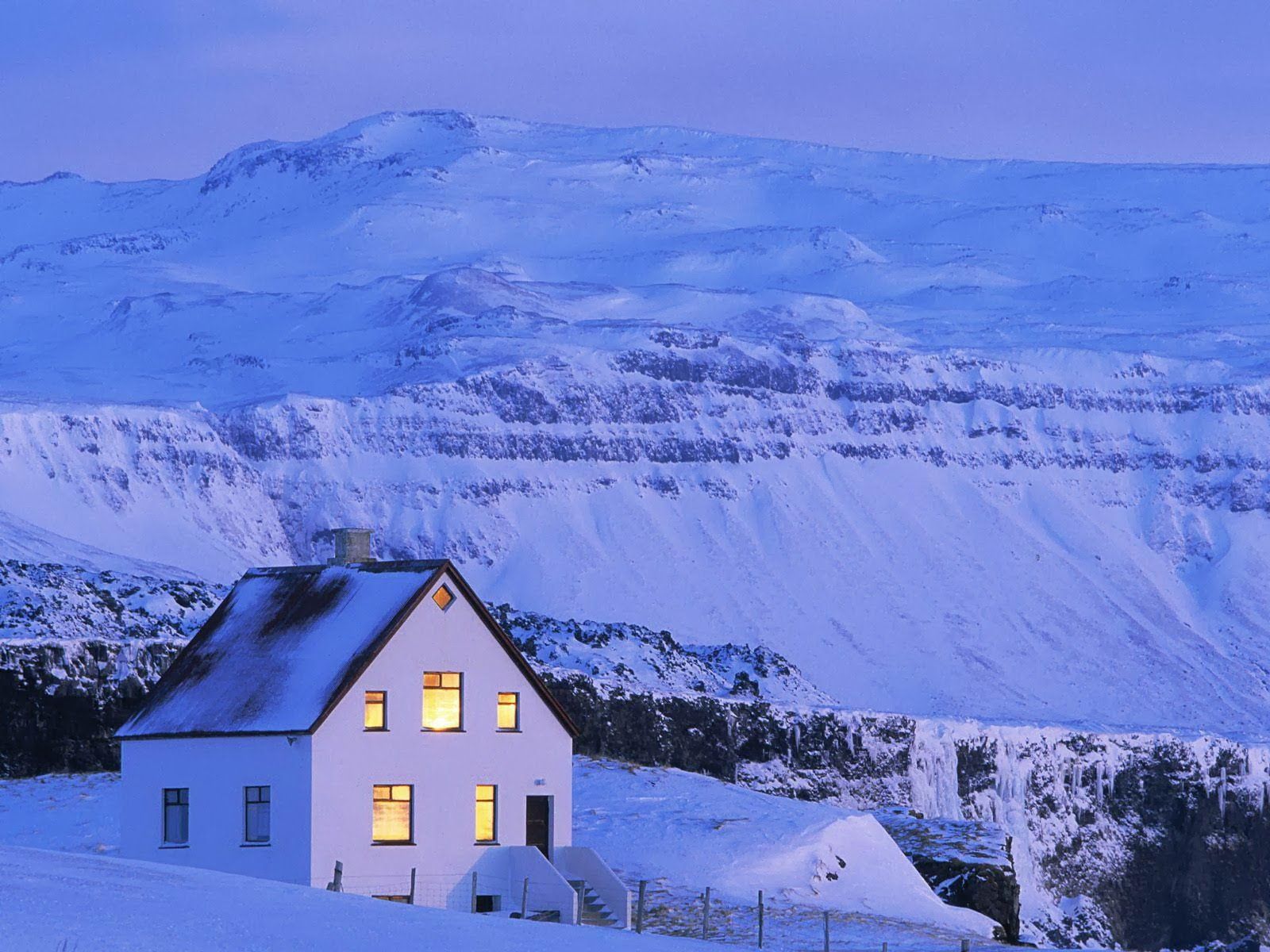 چشم انداز رویایی خانه در کوهستان برفی اسکاندیناوی تم بنفش	