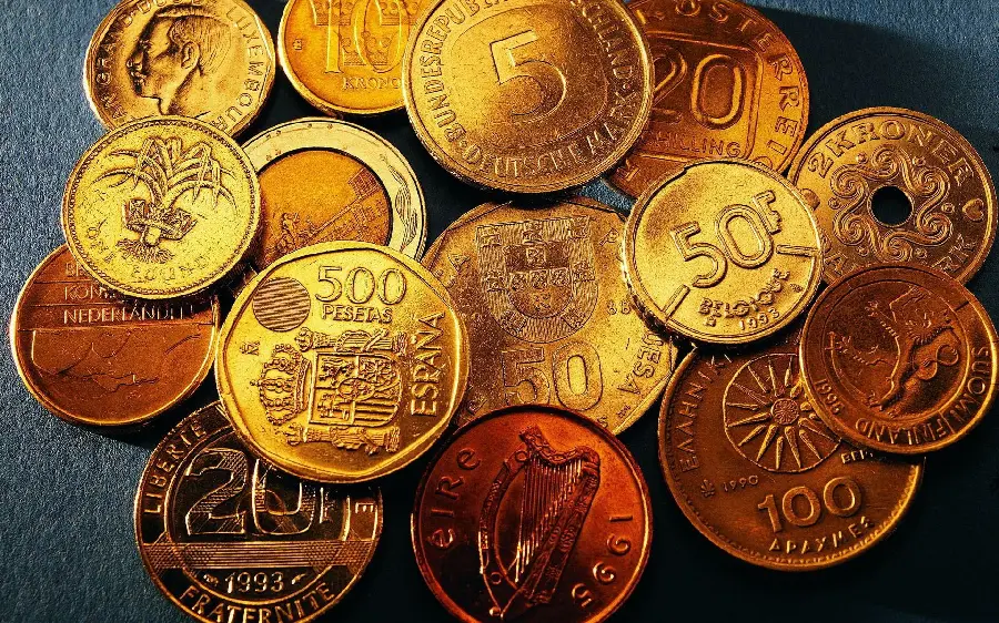 عکس با کیفیت تعدادی سکه طلا در پس زمینه تیره 