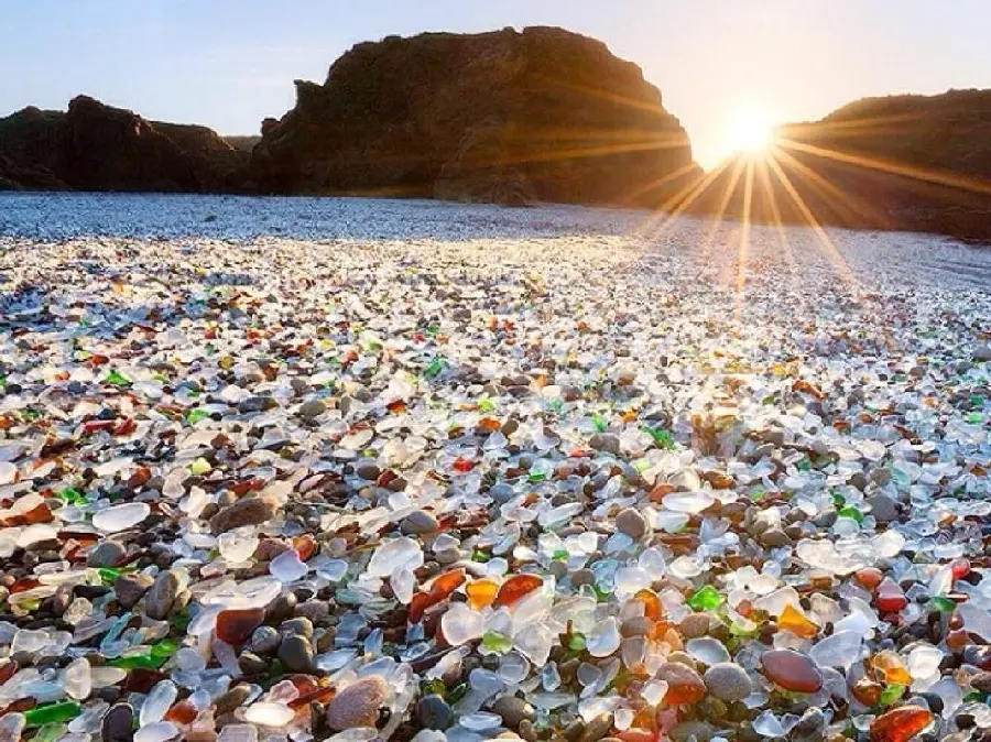 عکس شگفت انگیز سنگ های شیشه ای وقت طلوع آفتاب در ساحل