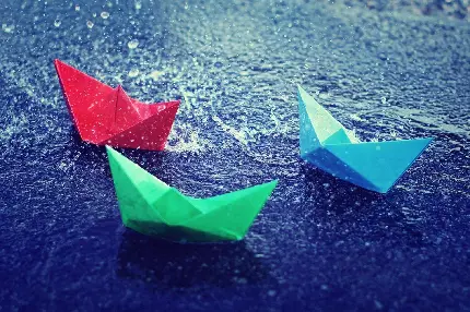 عکس زیبا قایق های کاغذی رنگی در زیر بارش شدید باران