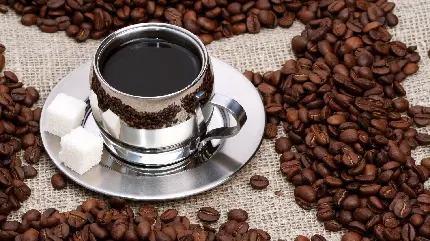 تصویرزمینه خاص فنجان قهوه ترک با تزئین دانه های قهوه روی میز