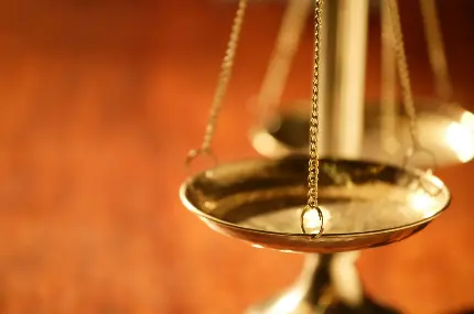 عکس استوک ترازوی عدالت طلایی رنگ از نمای بغل 