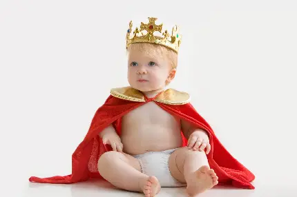 عکس استوک پسر بچه نوزاد با شنل پادشاهی قرمز و تاج سلطنتی