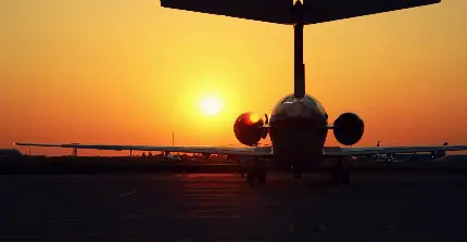 عکس پروفایل هواپیما در حال بلند شدن از باند فرودگاه هنگام طلوع
