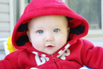 تصویر نوزاد خوشگل چشم آبی با سویشرت کلاه دار بامزه