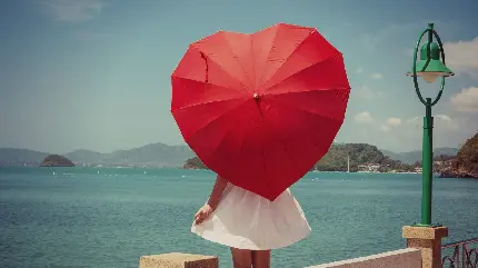 عکس پروفایل دخترونه شیک در کنار دریا با چتر قلبی شکل قرمز