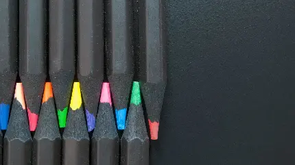 تصویر پس زمینه مشکی مات کامپیوتر و مداد رنگی های خیره کننده