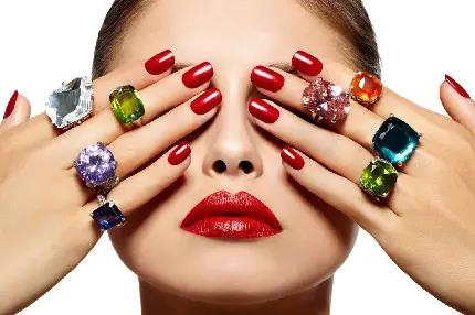 عکس استوک لاک قرمز ناخن قابل ست با رنگ های مختلف جواهرات