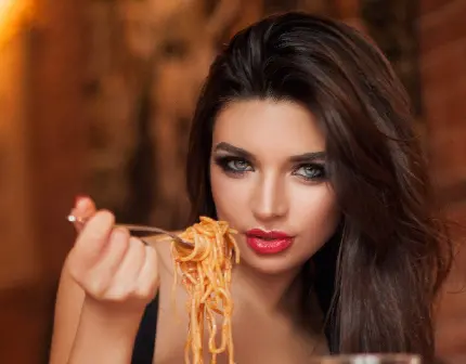 نمایی از دختر جذاب در حال سرو ماکارونی یا اسپاگتی در رستوران