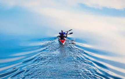 عکس استوک زیبای قایق تک نفره پارویی روی جریان آرام آب