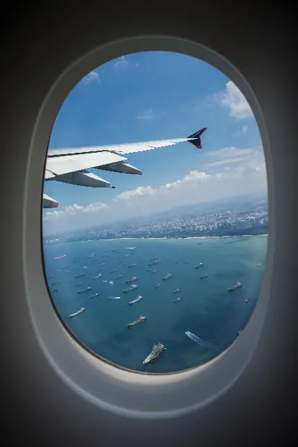 والپیپر پنجره هواپیما رو به منظره دریای پر از قایق و کشتی