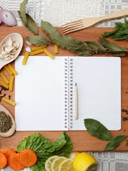 عکس تخته گوشت چوبی و دفترچه یادداشت مخصوص نوشتن دستور آشپزی