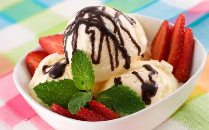 عکس بستنی وانیلی لوکس با تزئین سس شکلات و برگ نعنا و توت فرنگی