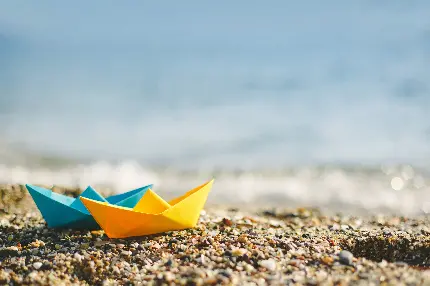 بک گراند دیدنی قایق های کاغذی آبی و زرد در ساحل دریا