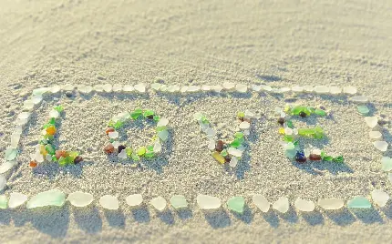 تصویر زمینه سنگ های شیشه ای ساحلی چیده شده به شکل LOVE