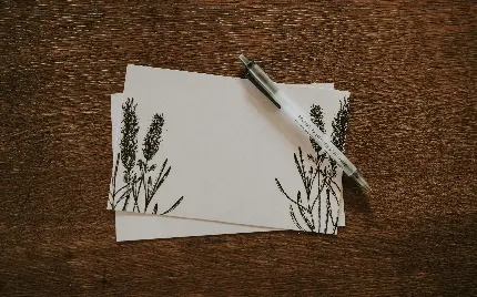تصویر قلم و کاغذ طراحی شده و هنری با زمینه چوبی دلچسب