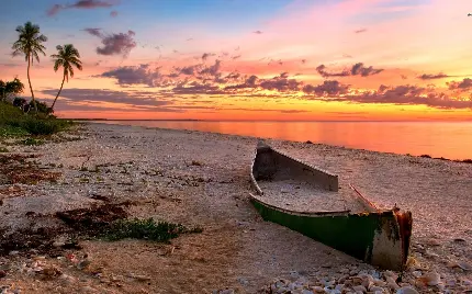 تصویر زمینه تماشایی قایق چوبی زیر شن رفته در ساحل دریا