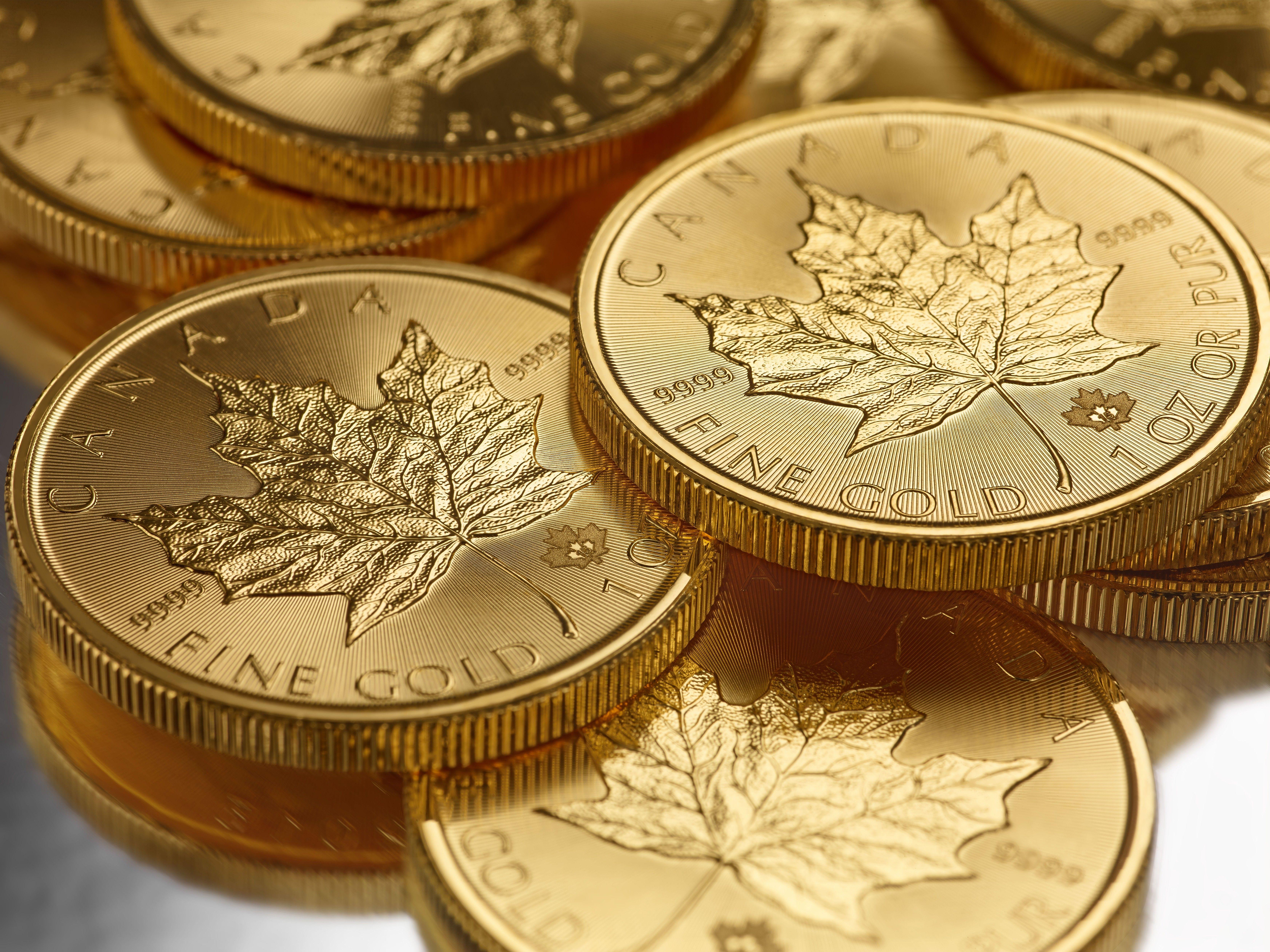 تصویر سکه های طلا با طرح ناب برگ در پس زمینه سفید 