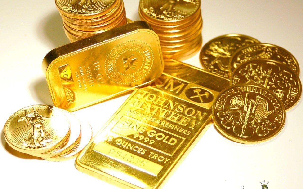 سکه های زیبای طلا در کنار چند شمش طلا با پس زمینه سفید 