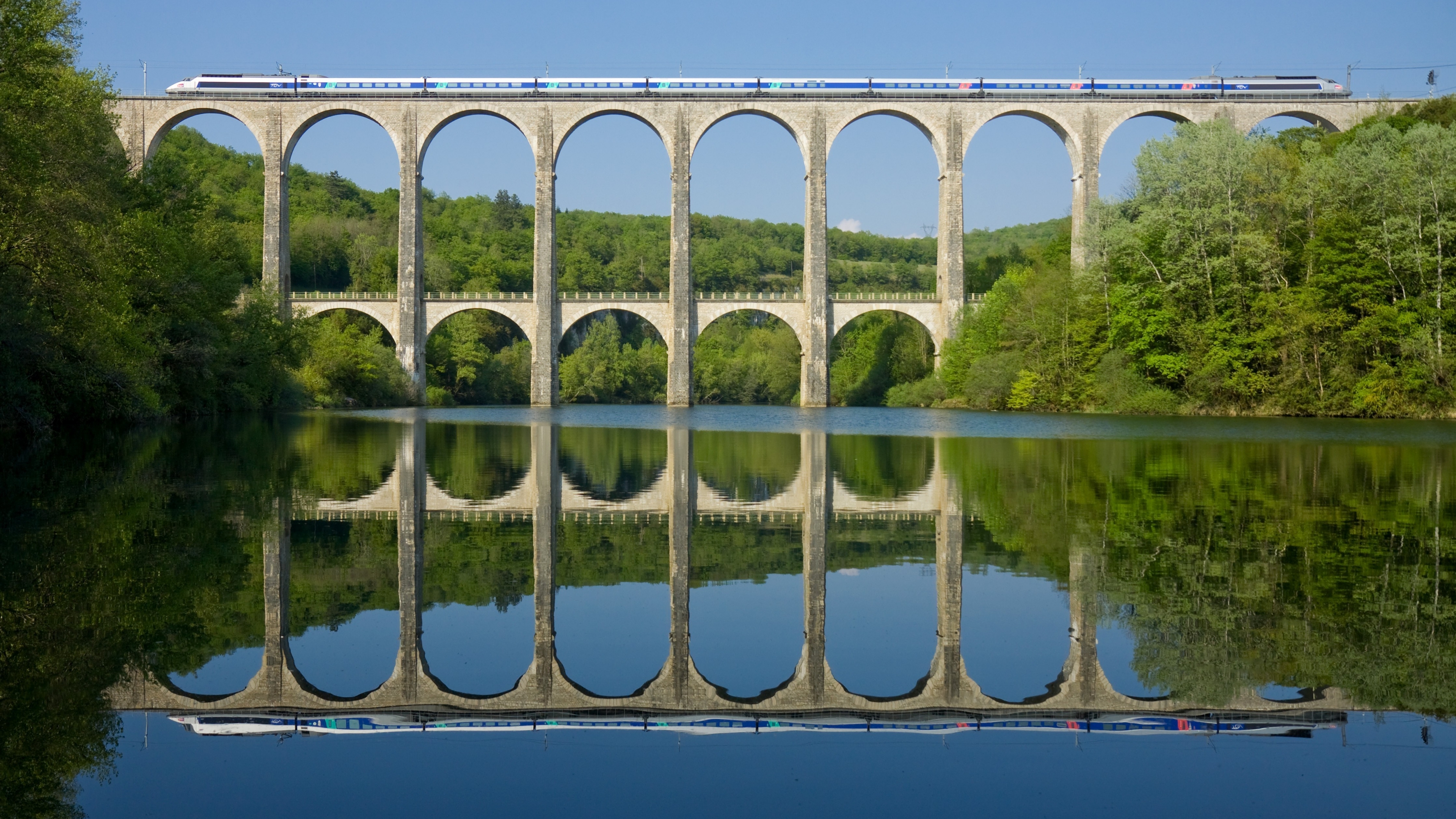 عکس انعکاس قطار روی پل در آب دریاچه مناسب چاپ روی کارت دعوت شیک