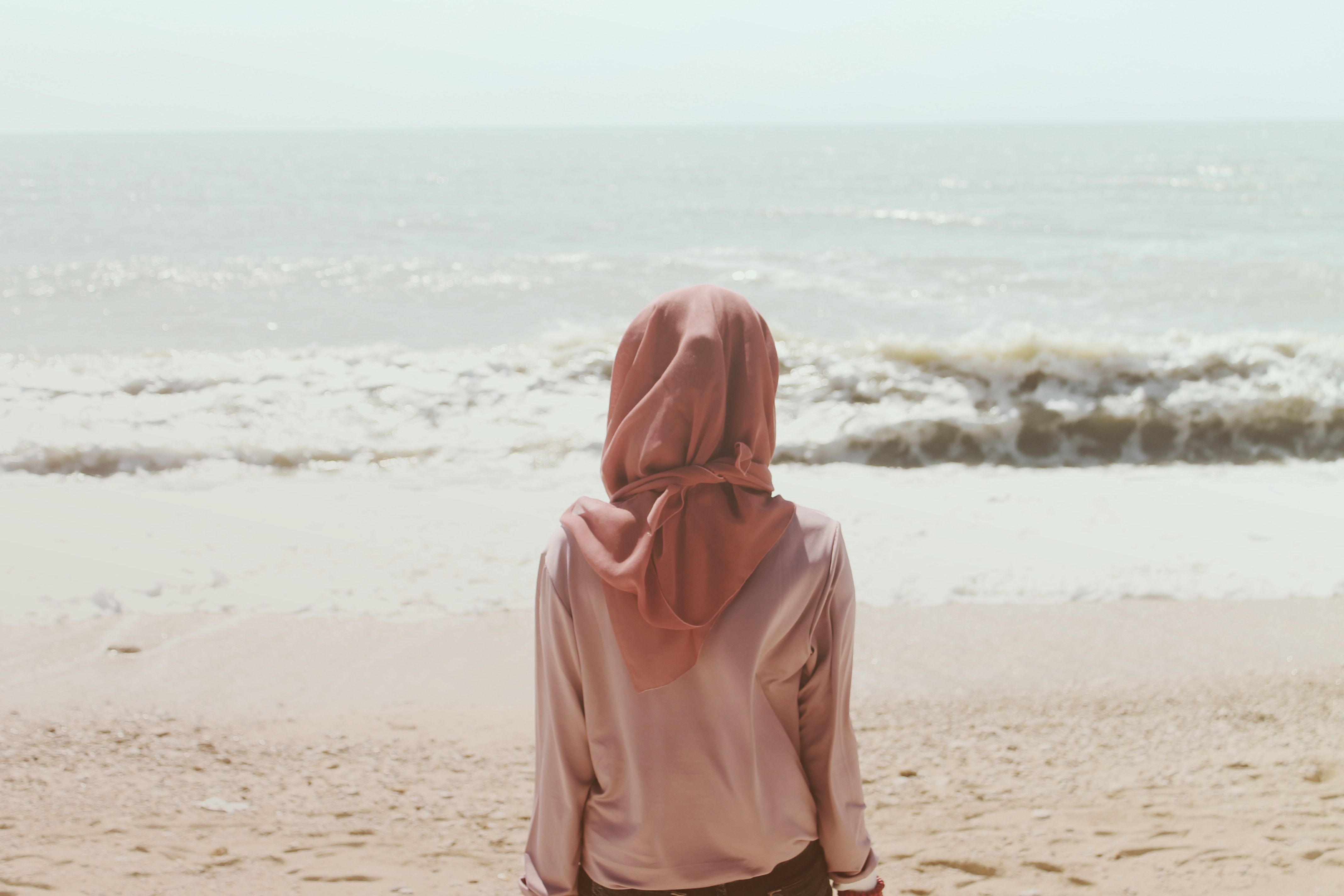 تصویر پروفایل دختر با حجاب از پشت نشسته روی ساحل رو به دریا